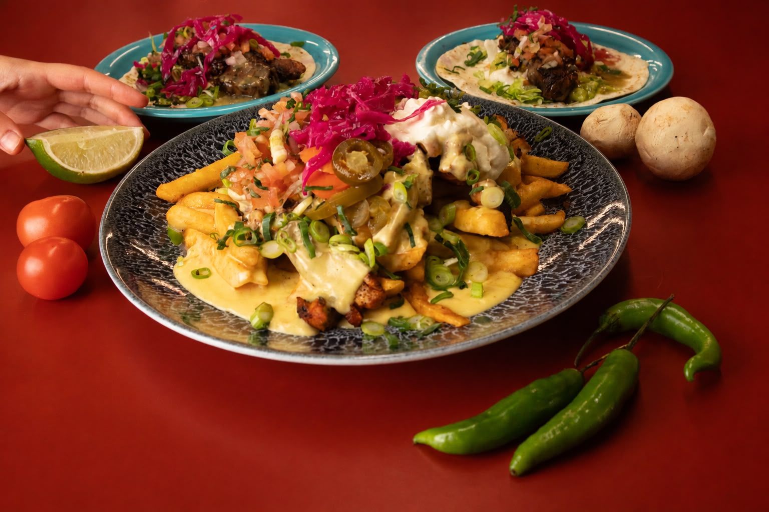 Loaded fries being shared with tacos on the side